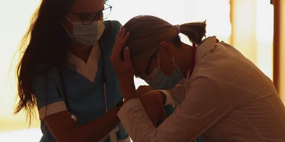 a nurse consoling another nurse