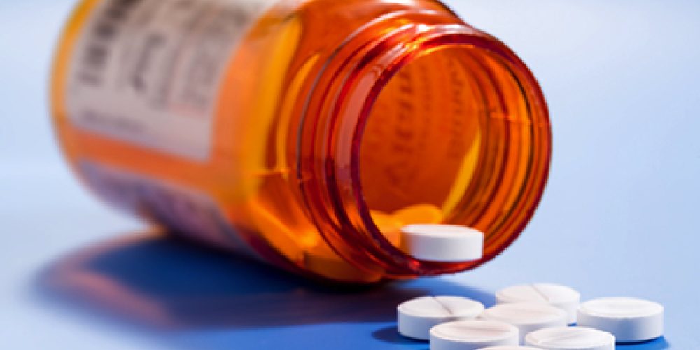 prescription pills falling out of bottle onto table